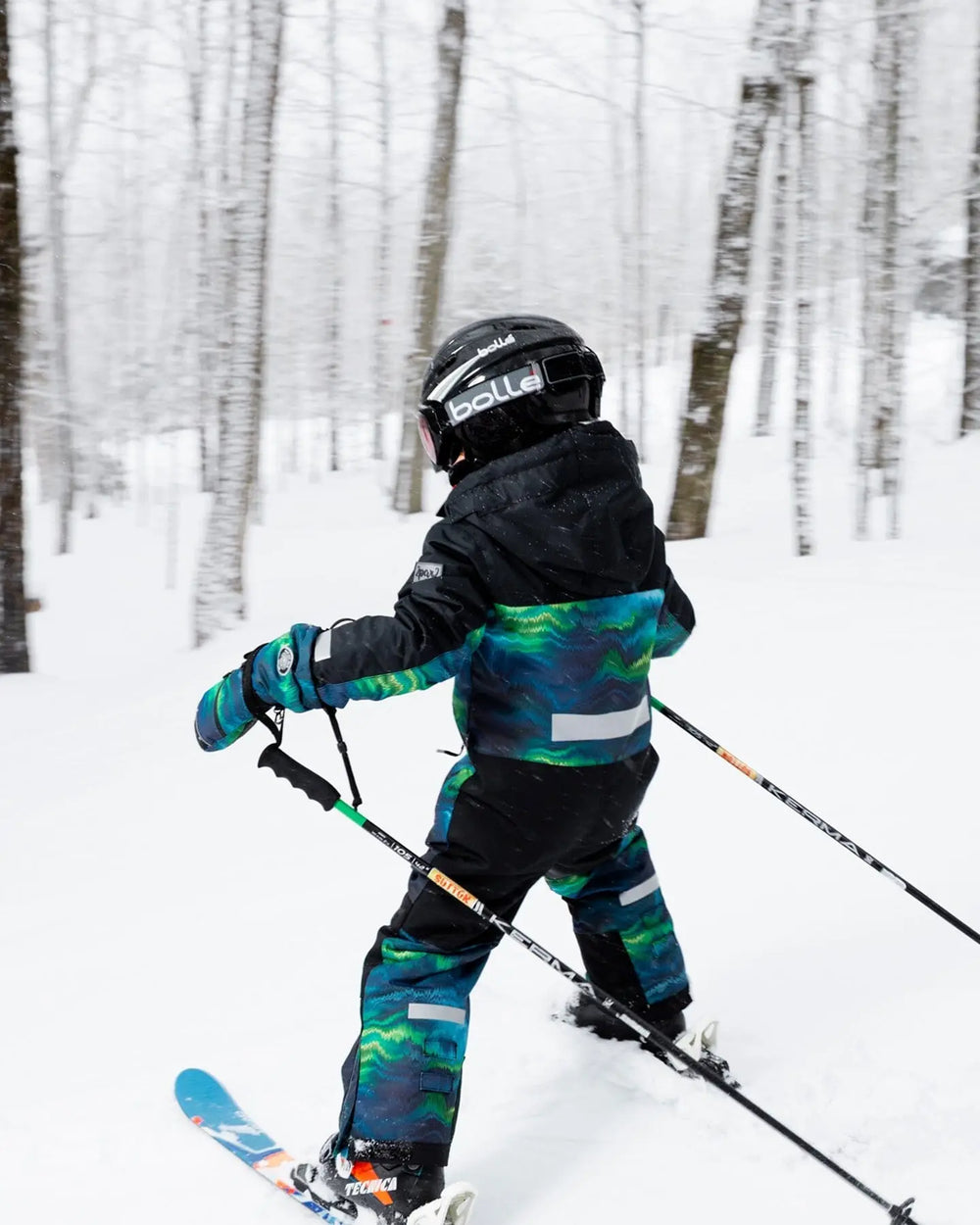 Action shot of kid in Teknik snowsuit with helmet-friendly hood and waterproof zippers