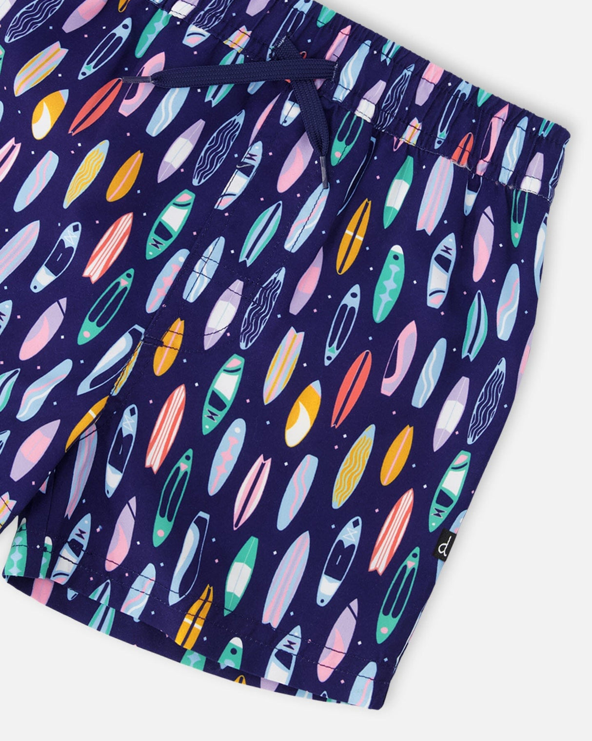 Close-up of waistband, drawstring, and colorful surfboard pattern on swim shorts