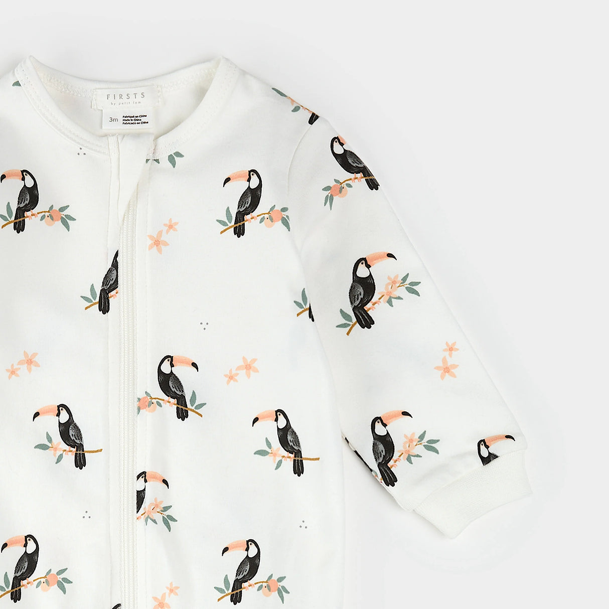 Close-up of ribbed cuffs and toucan print on organic cotton baby sleeper