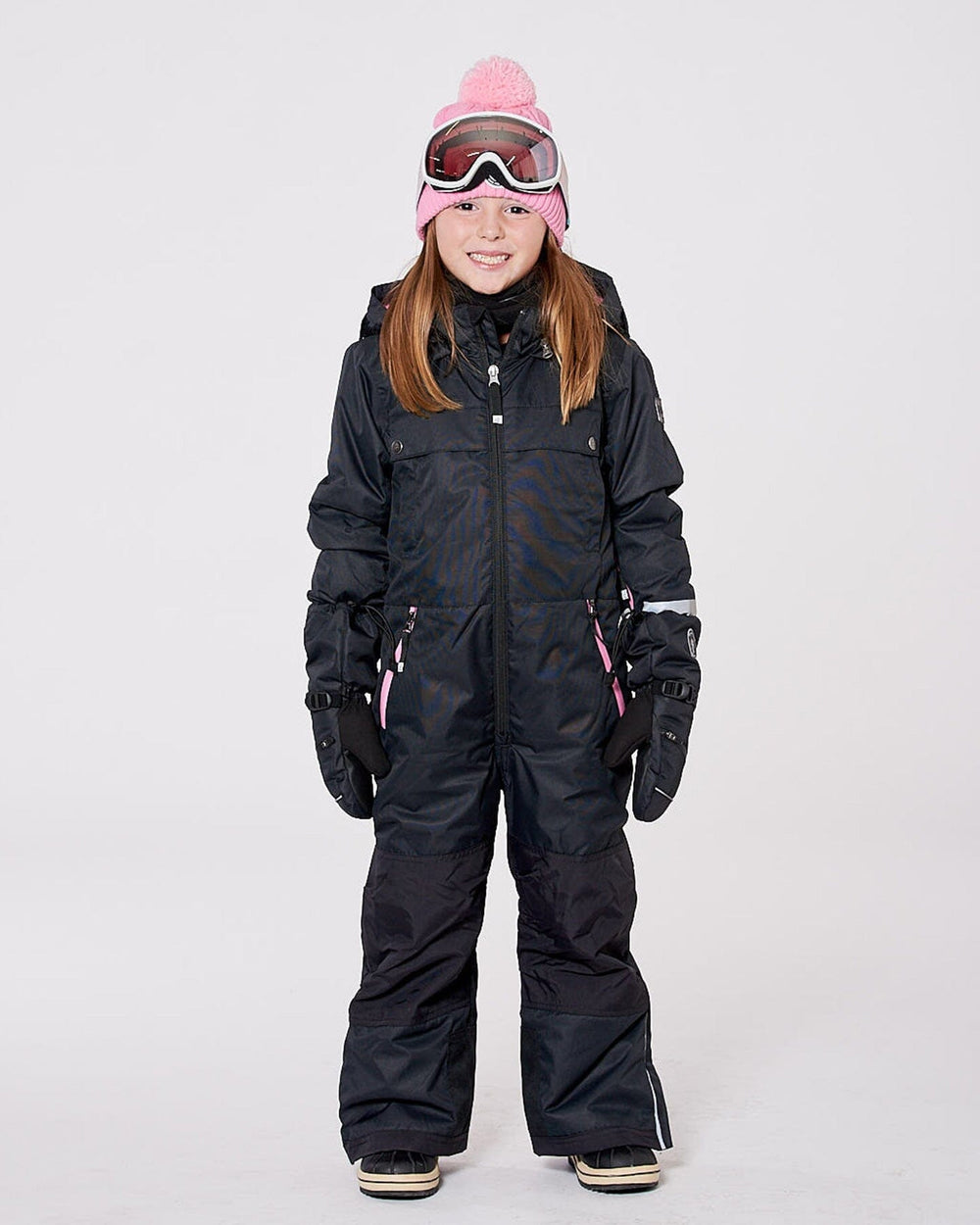 Girl wearing black one-piece Teknik snowsuit with pink hood — front view on snow