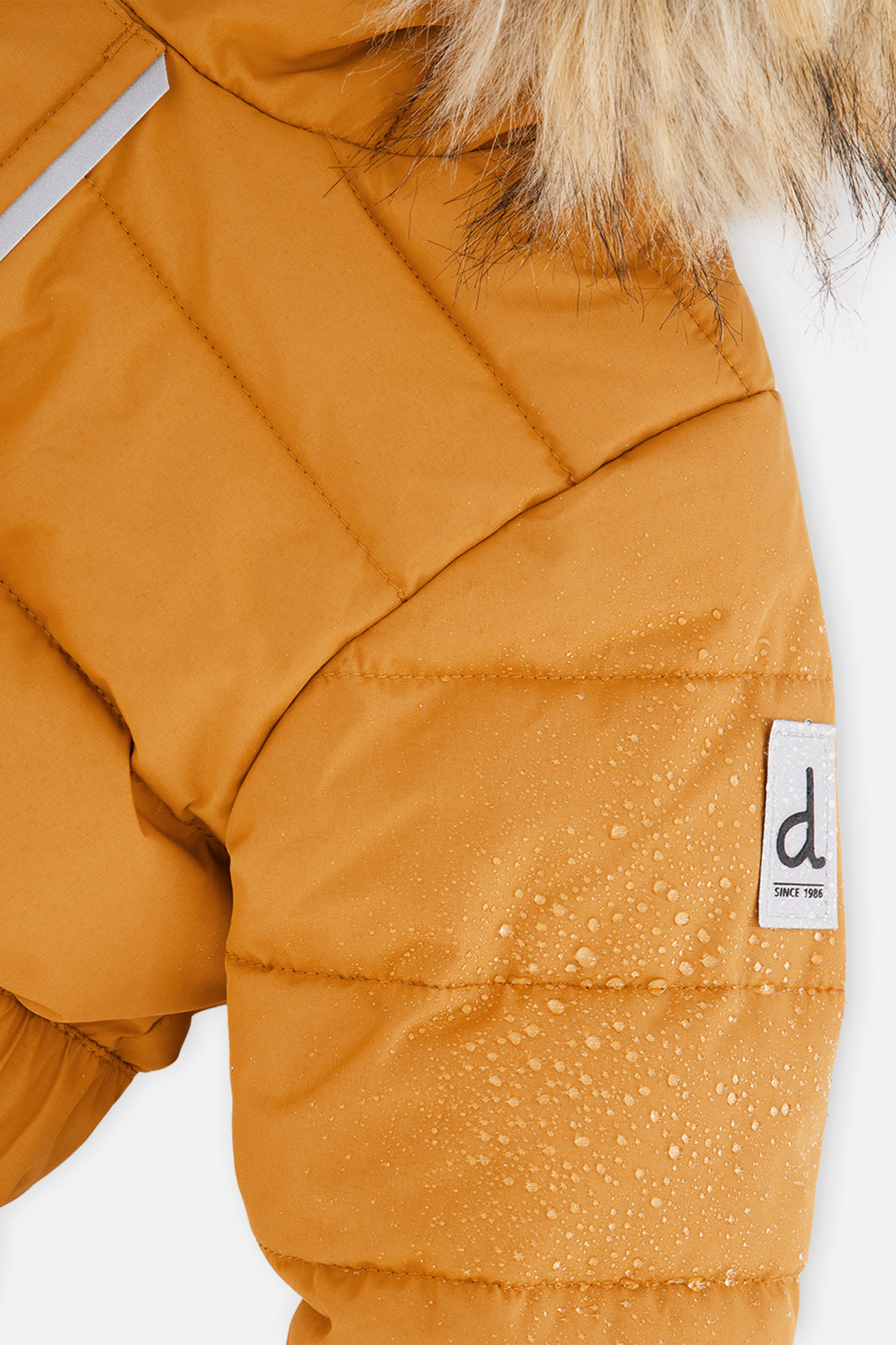 Close-up of the Brown Sugar quilted shoulder with reflective details and logo tab