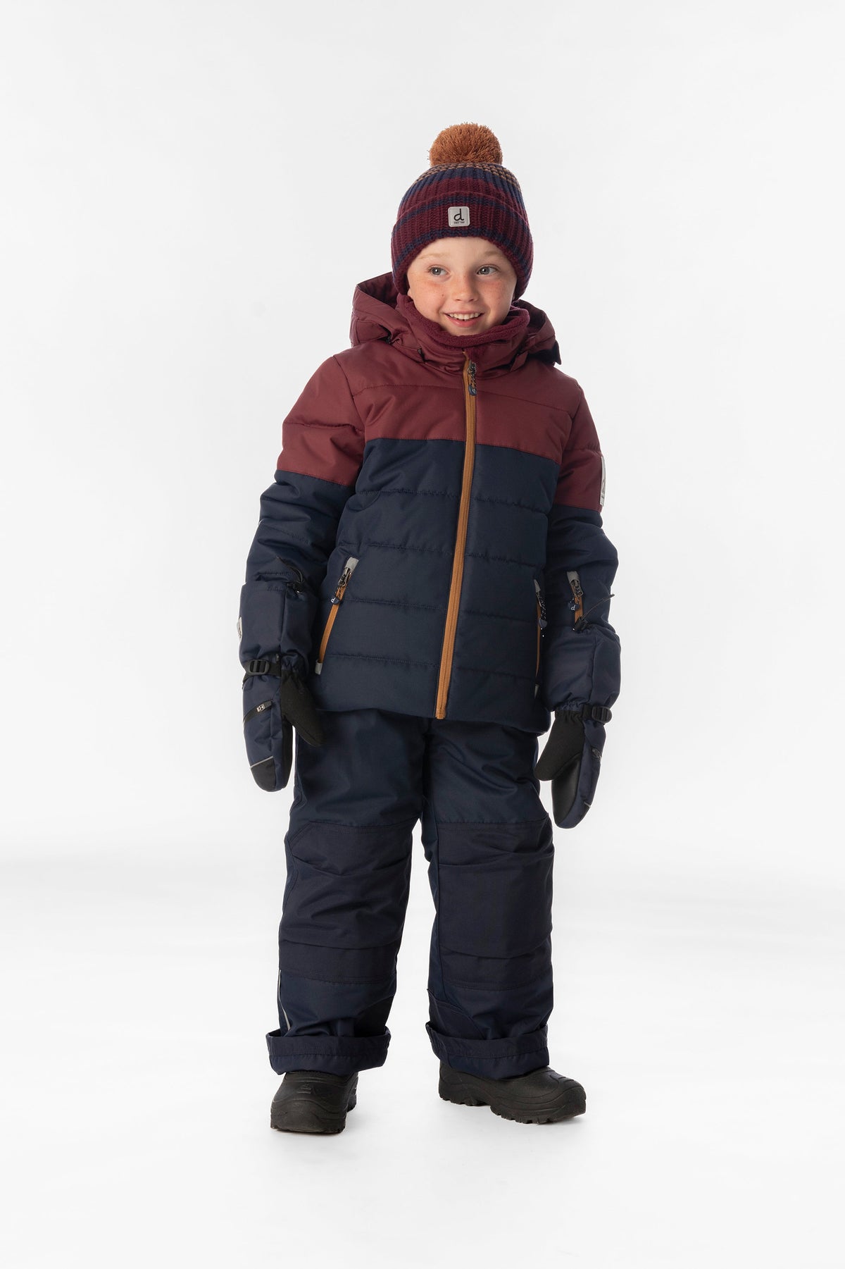 Child wearing the Deux par Deux PLAY snowsuit in navy and burgundy, lookbook view 1
