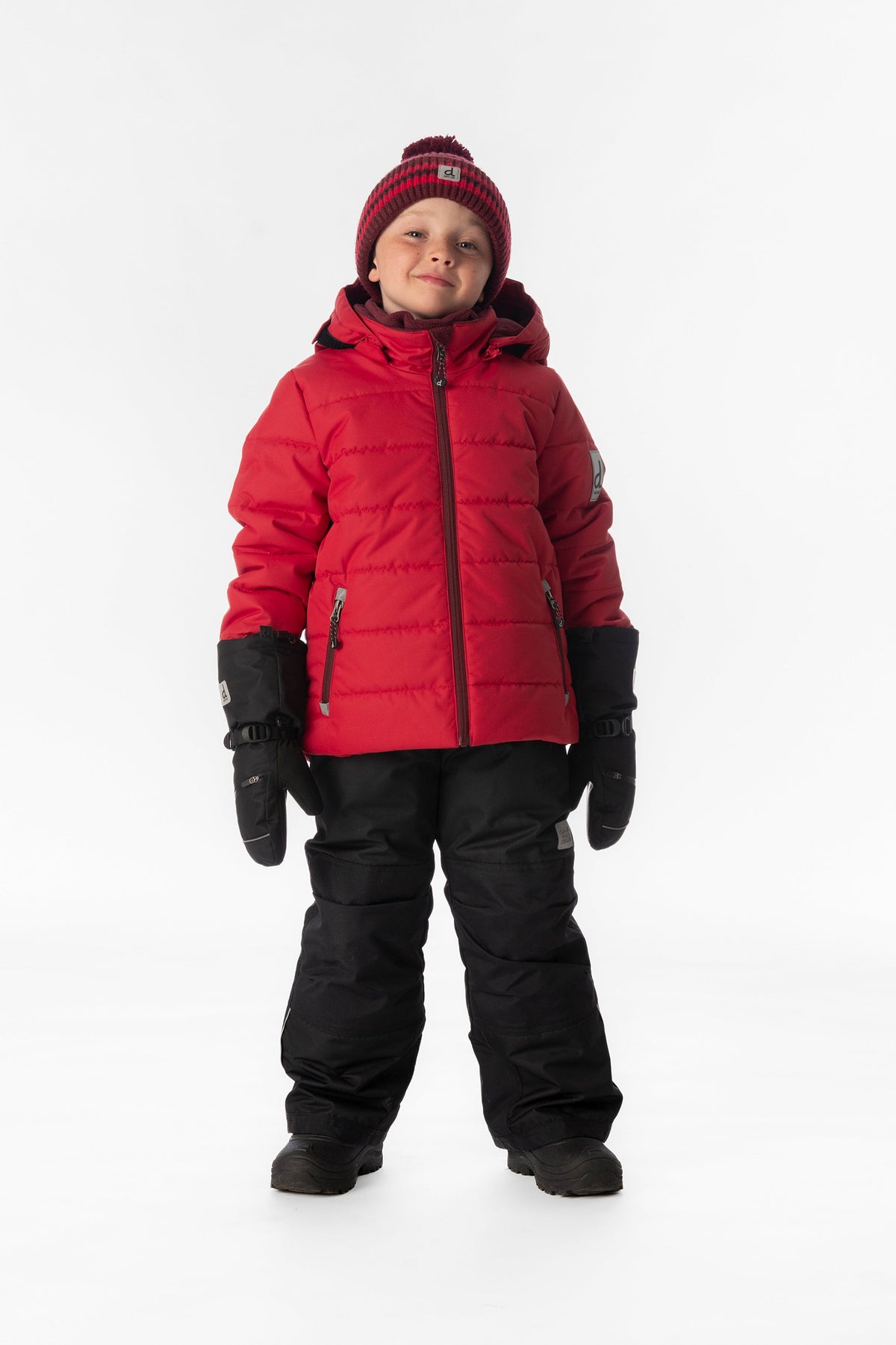 Child wearing the Deux par Deux PLAY snowsuit in red with black pants, lookbook view 1