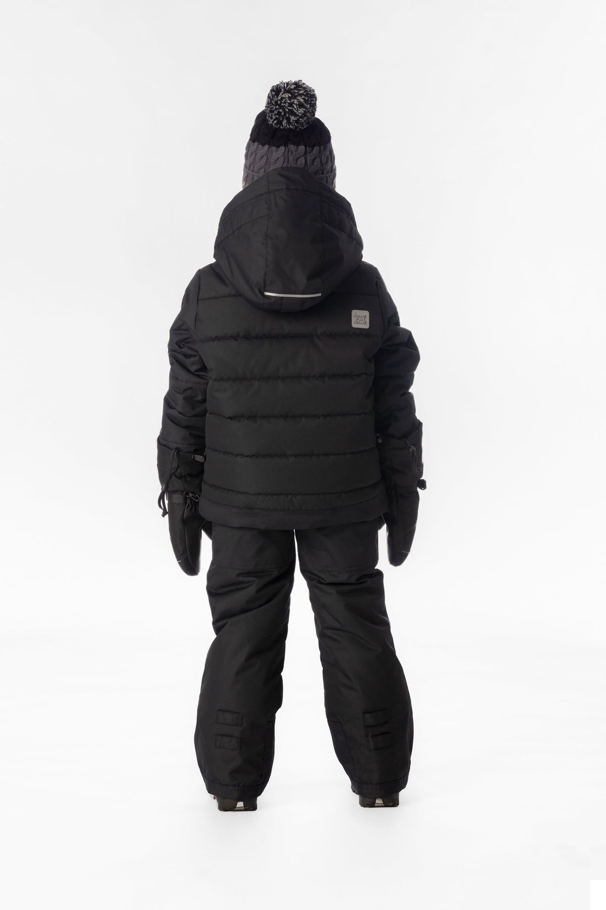Child wearing the black Deux par Deux PLAY snowsuit, lookbook view 3