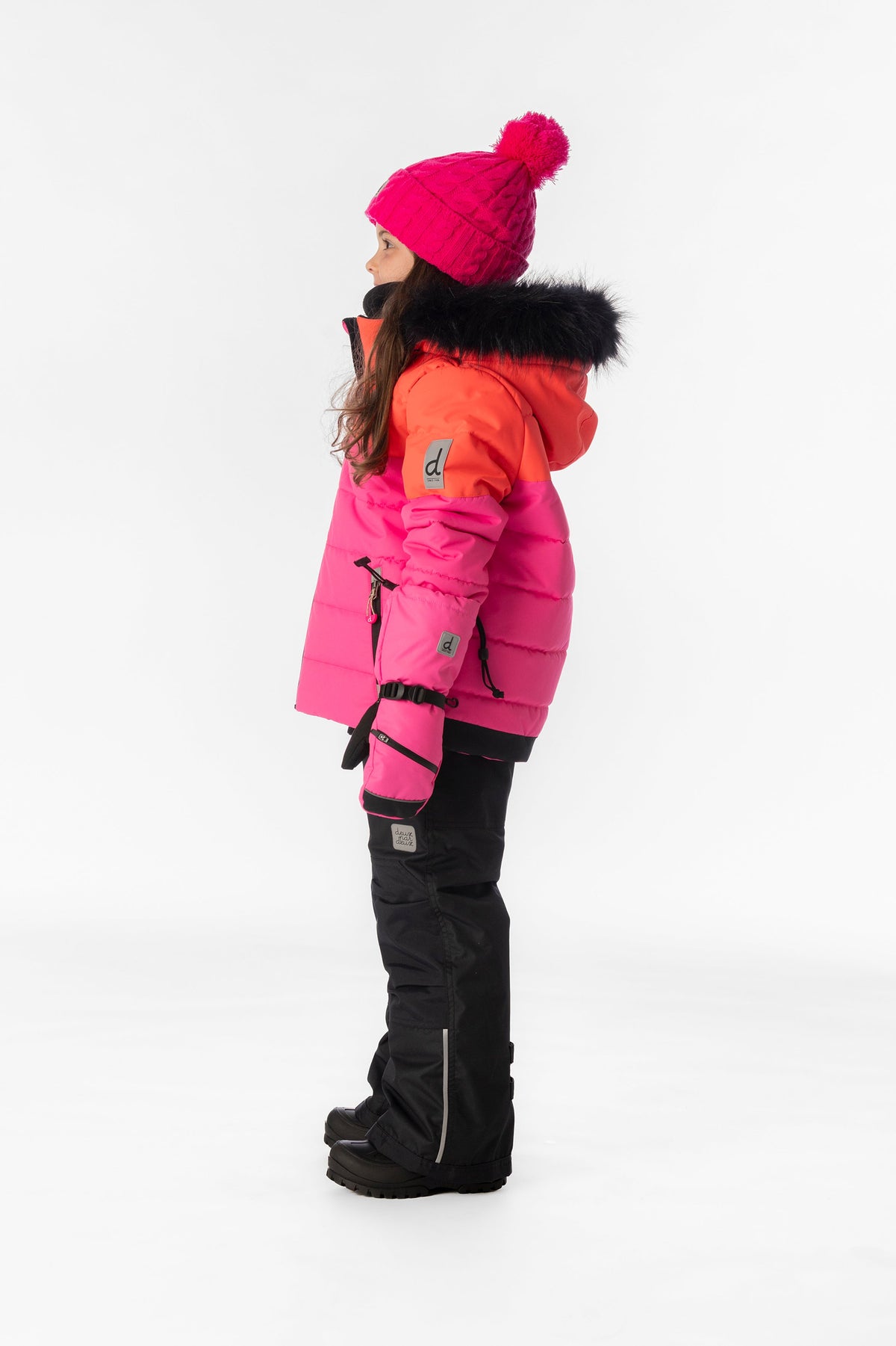 Child wearing the bright pink Deux par Deux PLAY snowsuit, lookbook view 2