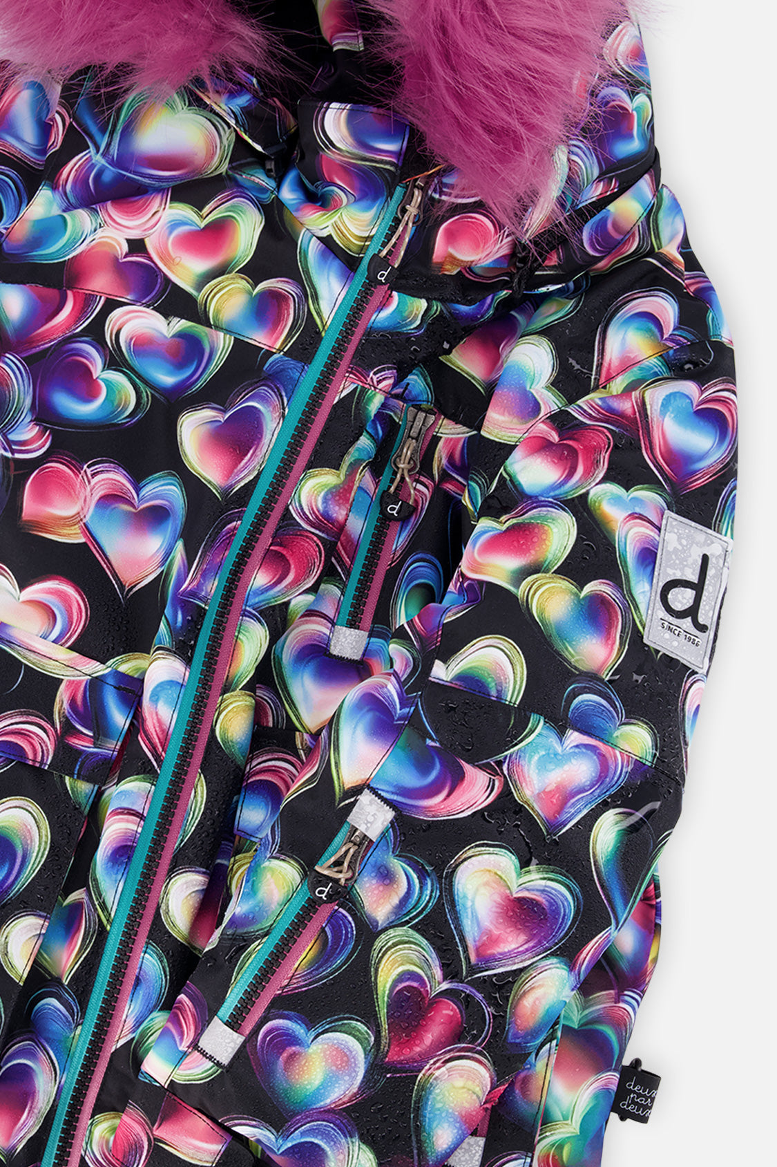 Close-up of the heart-print PLAY jacket front zipper, chest pocket and sleeve logo patch