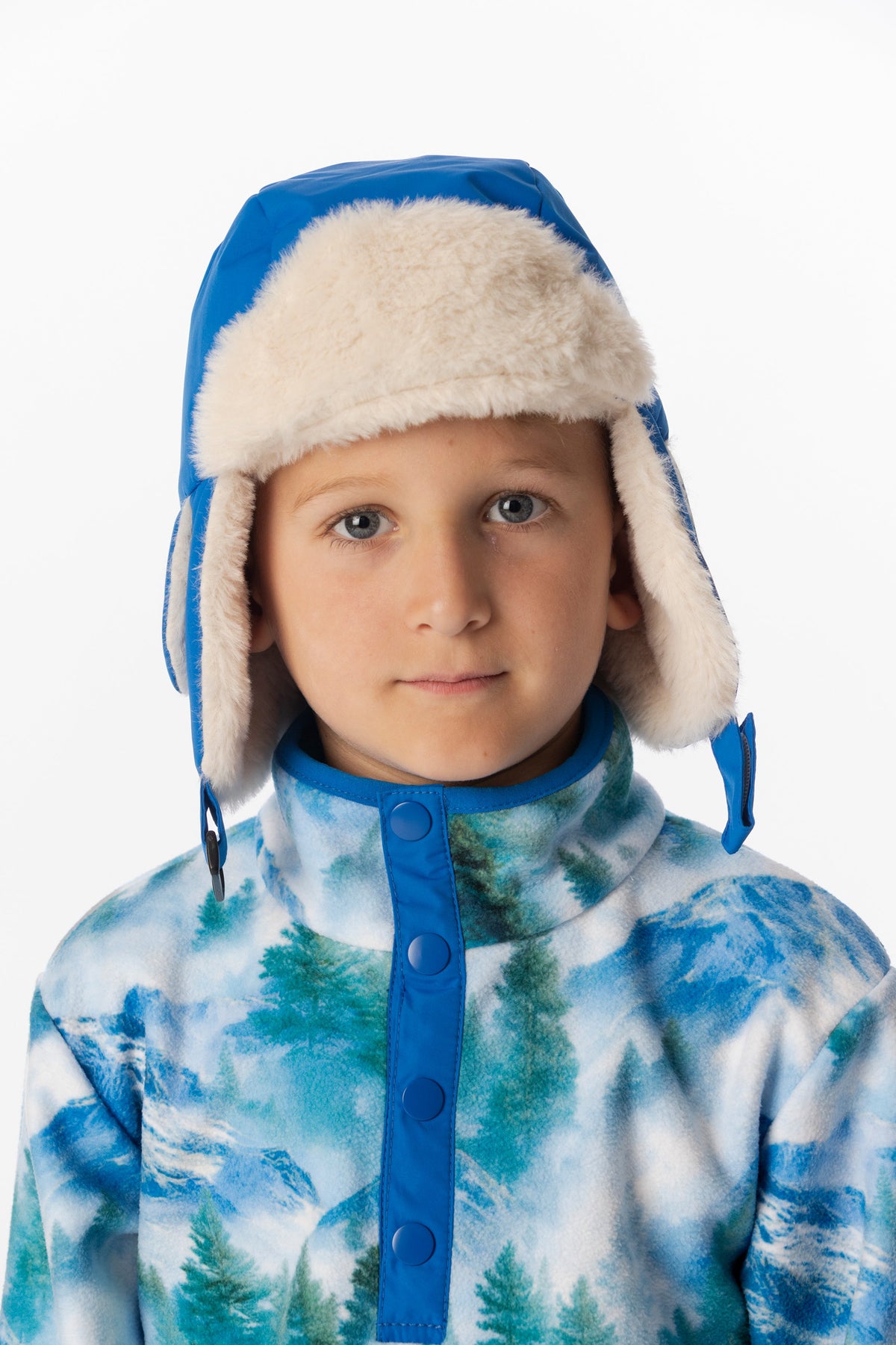 Child wearing the blue Deux par Deux lined chapka with the ear flaps down, front portrait