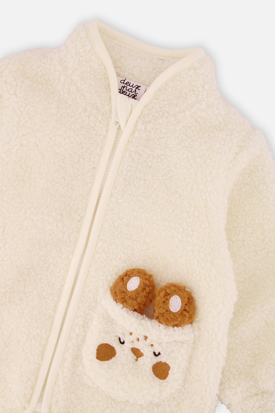 Close-up of the stand-up collar, zipper and bunny pocket on the off-white baby sherpa jacket