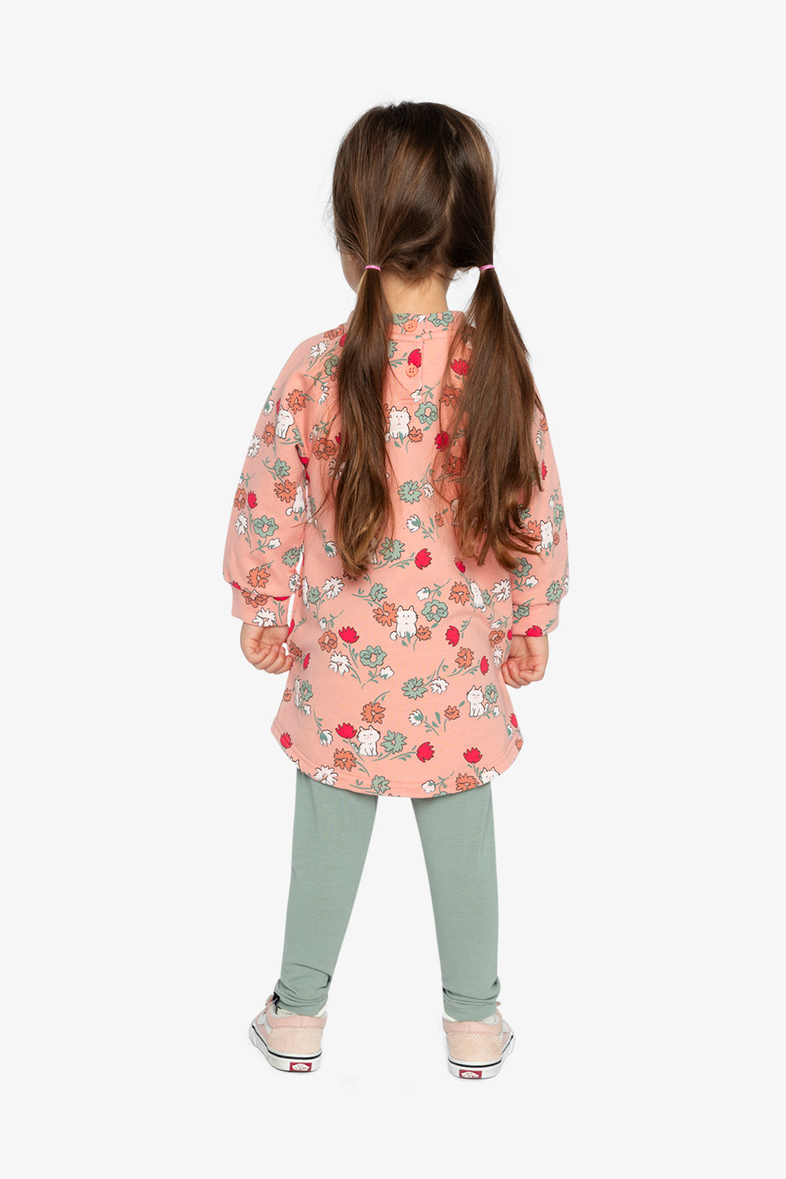 Child wearing the Deux par Deux coral pink cat print dress with sage green leggings, back view