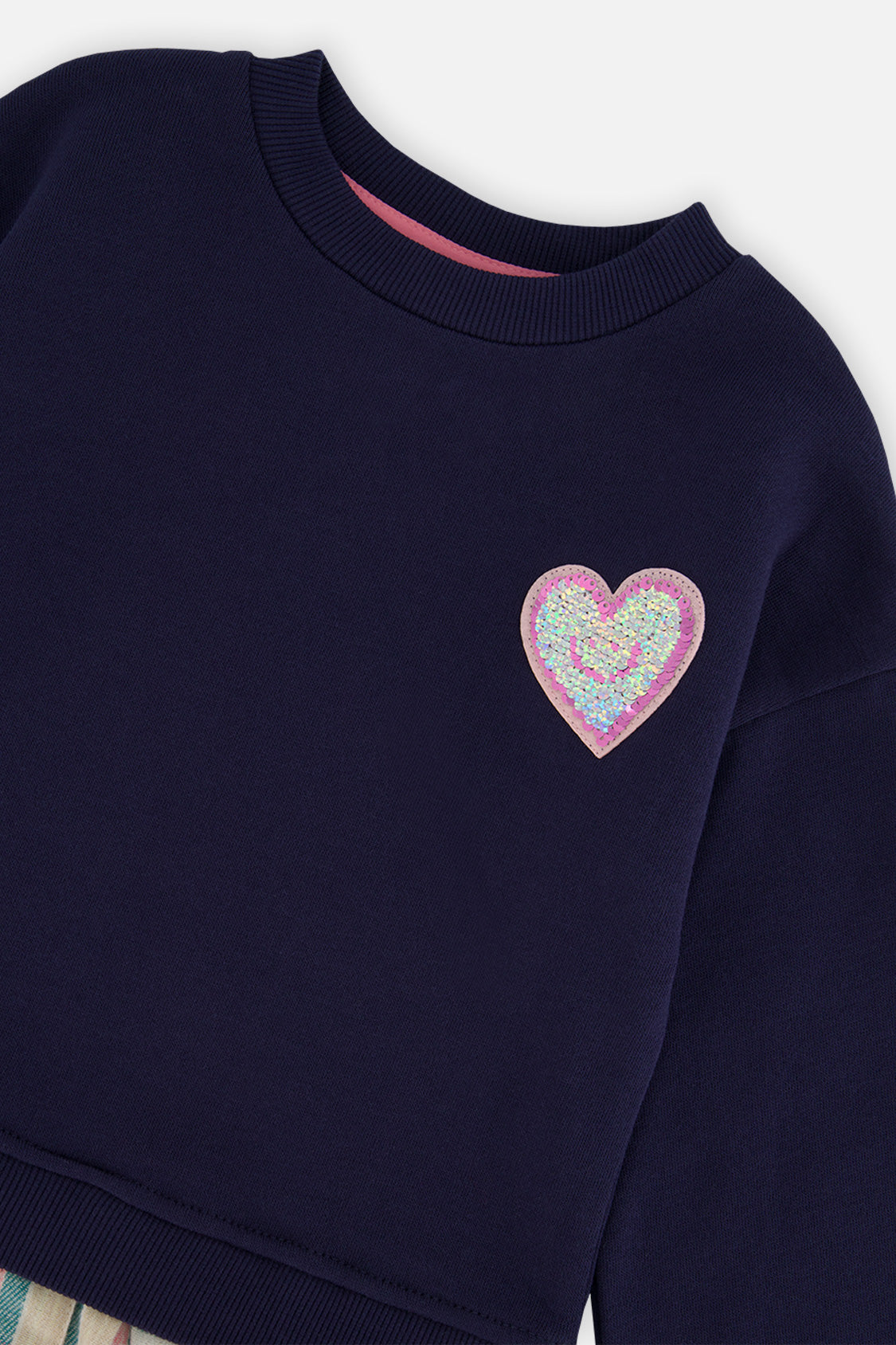 Close-up of the glittery heart patch and crew neckline on the Deux par Deux navy dress