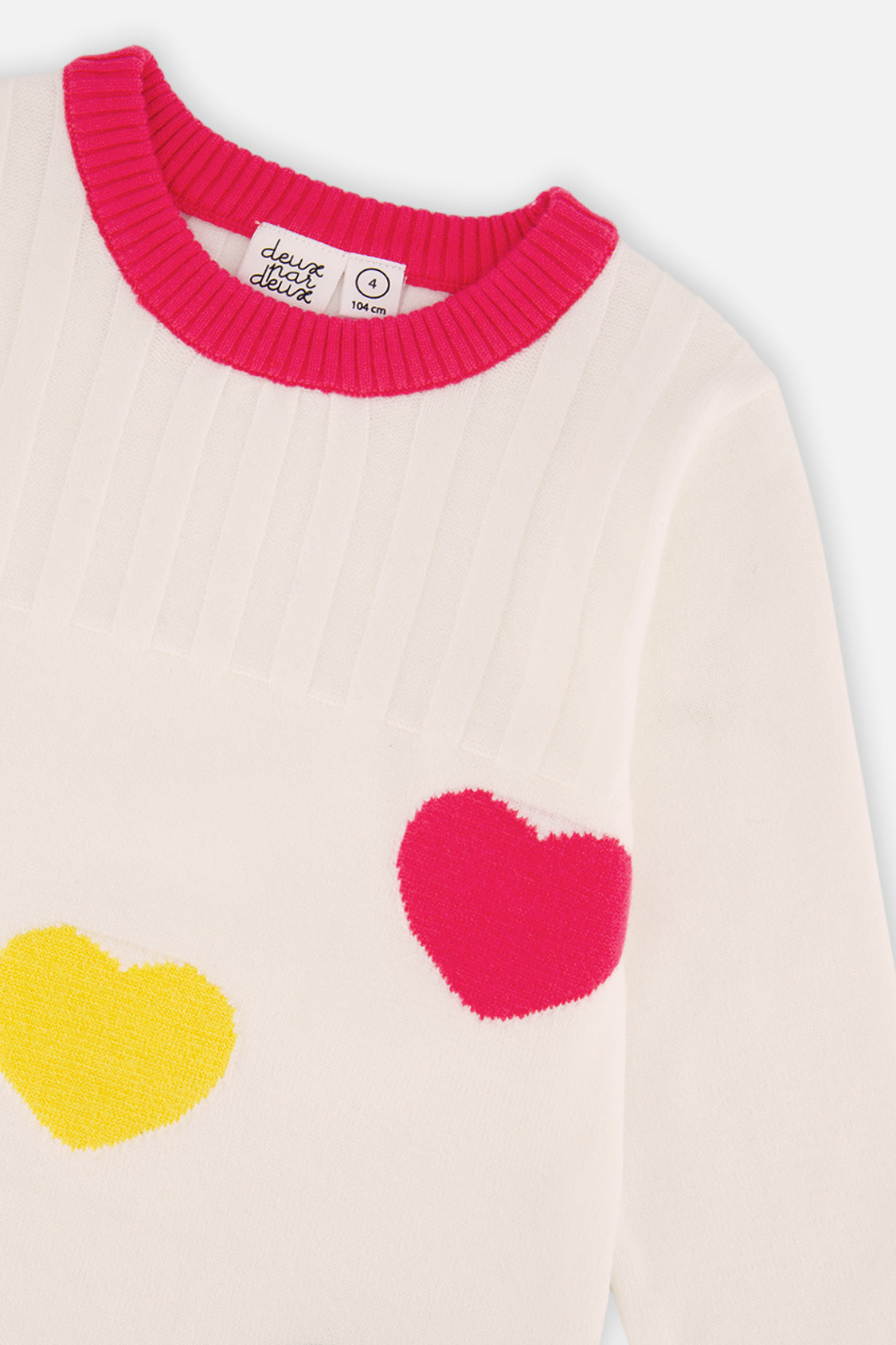 Close-up of the pink ribbed neckline and heart jacquard on the off-white dress