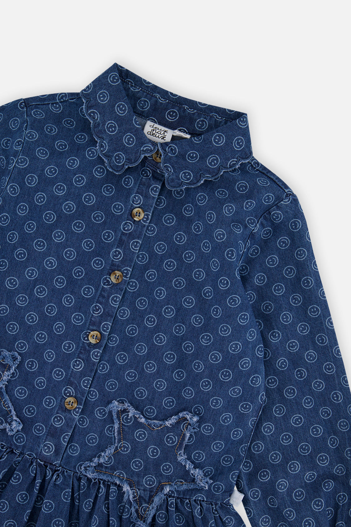Close-up of the scalloped collar and frayed star patch on the Deux par Deux blue smiley dress