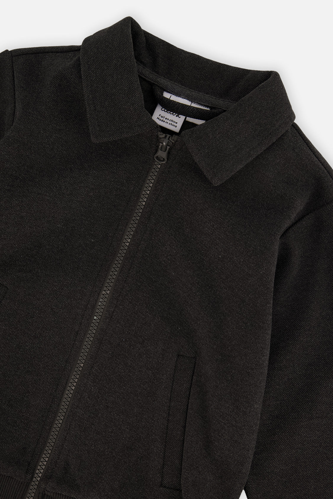 Close-up of the collar and angled front zipper on the black front zip jacket