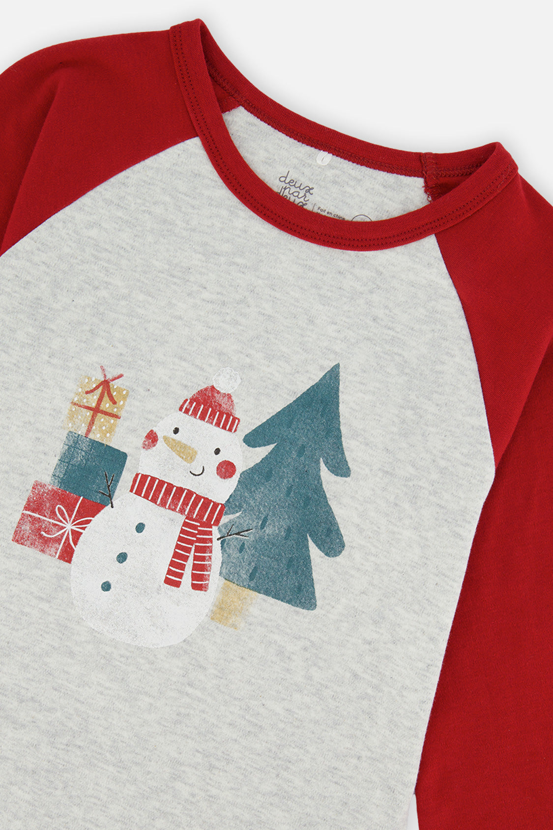 Close-up of the snowman in a red hat with gift boxes and a pine tree on the oatmeal top