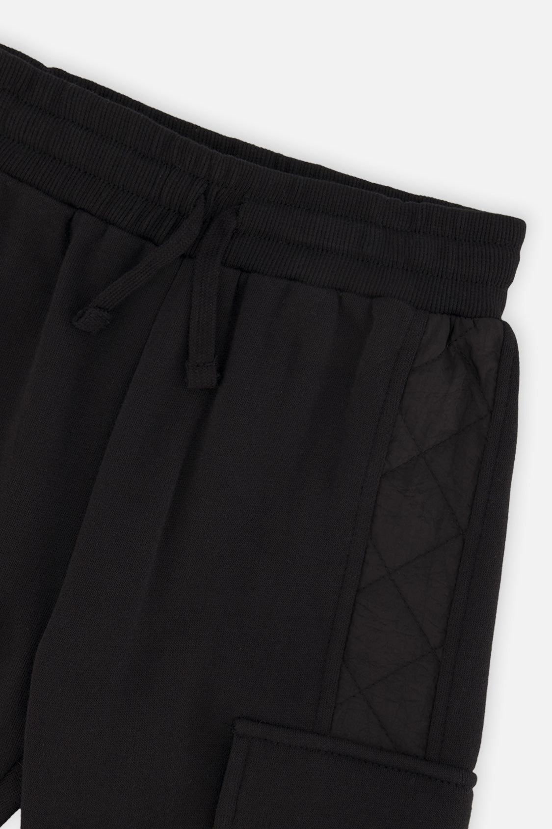 Close-up of the drawstring waistband and quilted side panel on the black cargo sweatpants