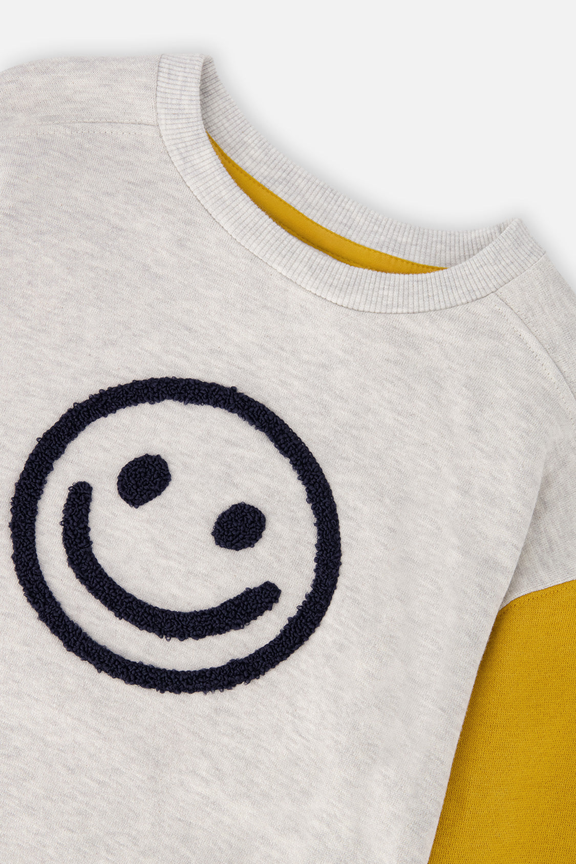 Close-up of the textured navy smiley face and ribbed neckline on the heather grey Deux par Deux sweatshirt
