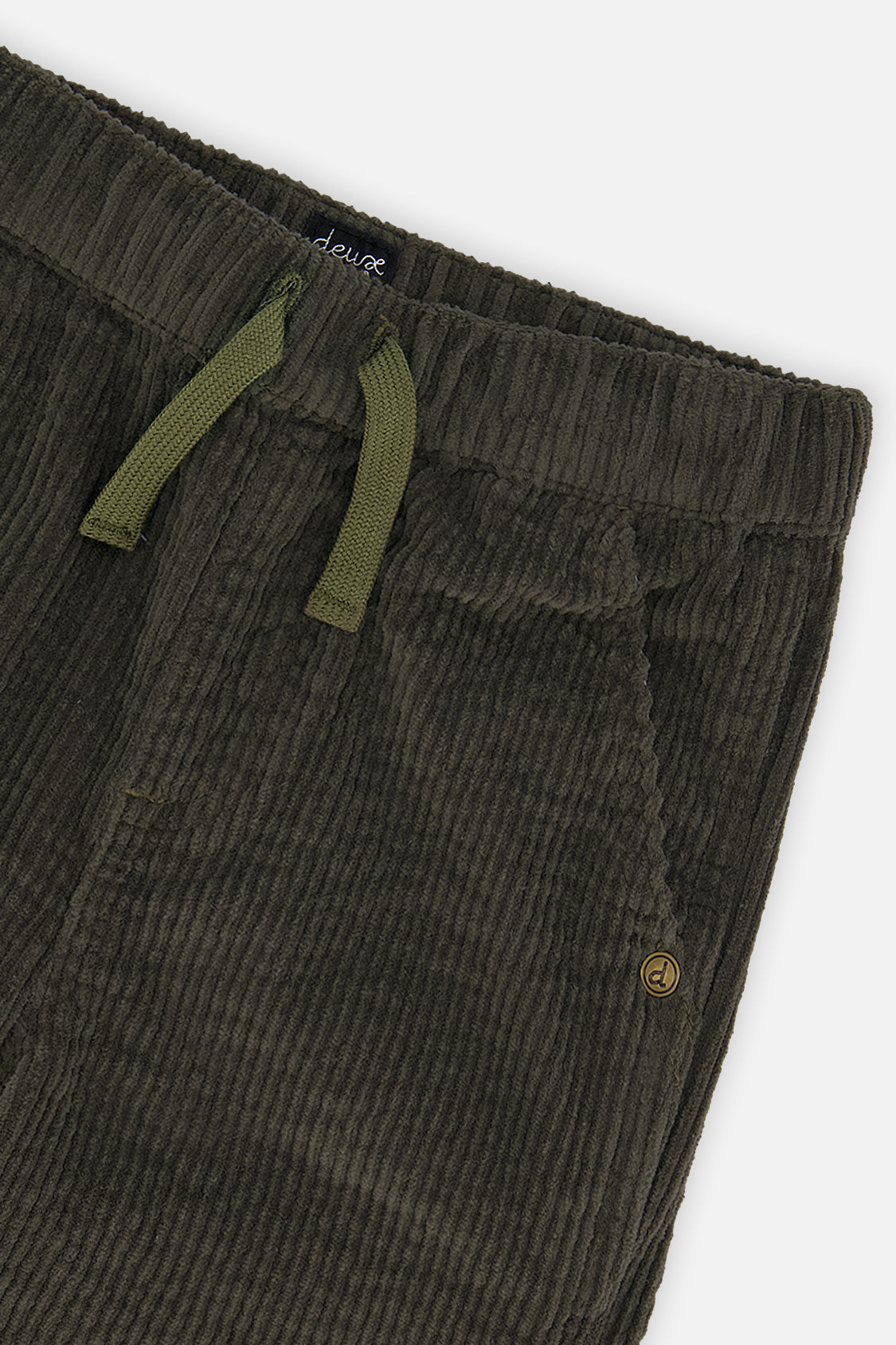 Close-up of the elastic waist, green drawcord and pocket on dark grey stretch corduroy pants