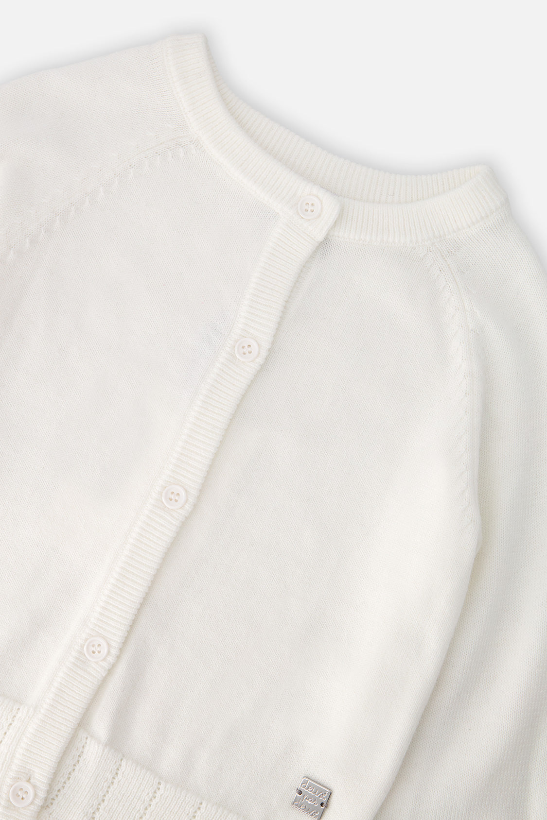 Close-up of the buttons and ribbed neckline on the off-white Deux par Deux cardigan