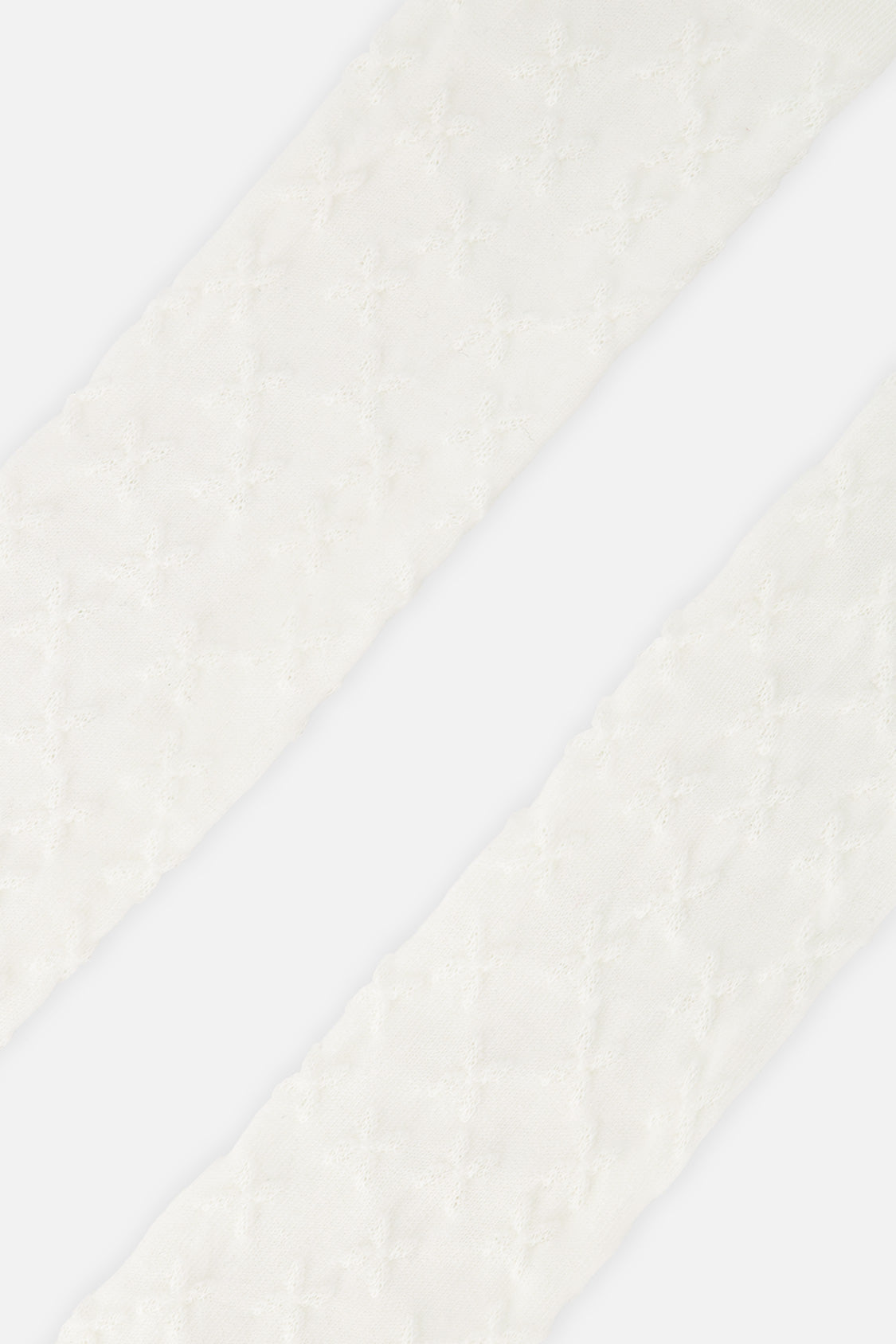 Close-up of the raised tonal pattern on the off-white Deux par Deux baby tights