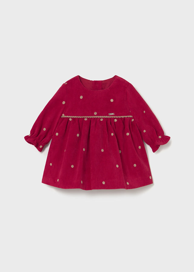 Front view of cherry-red polka-dot baby dress with long sleeves and gathered skirt.