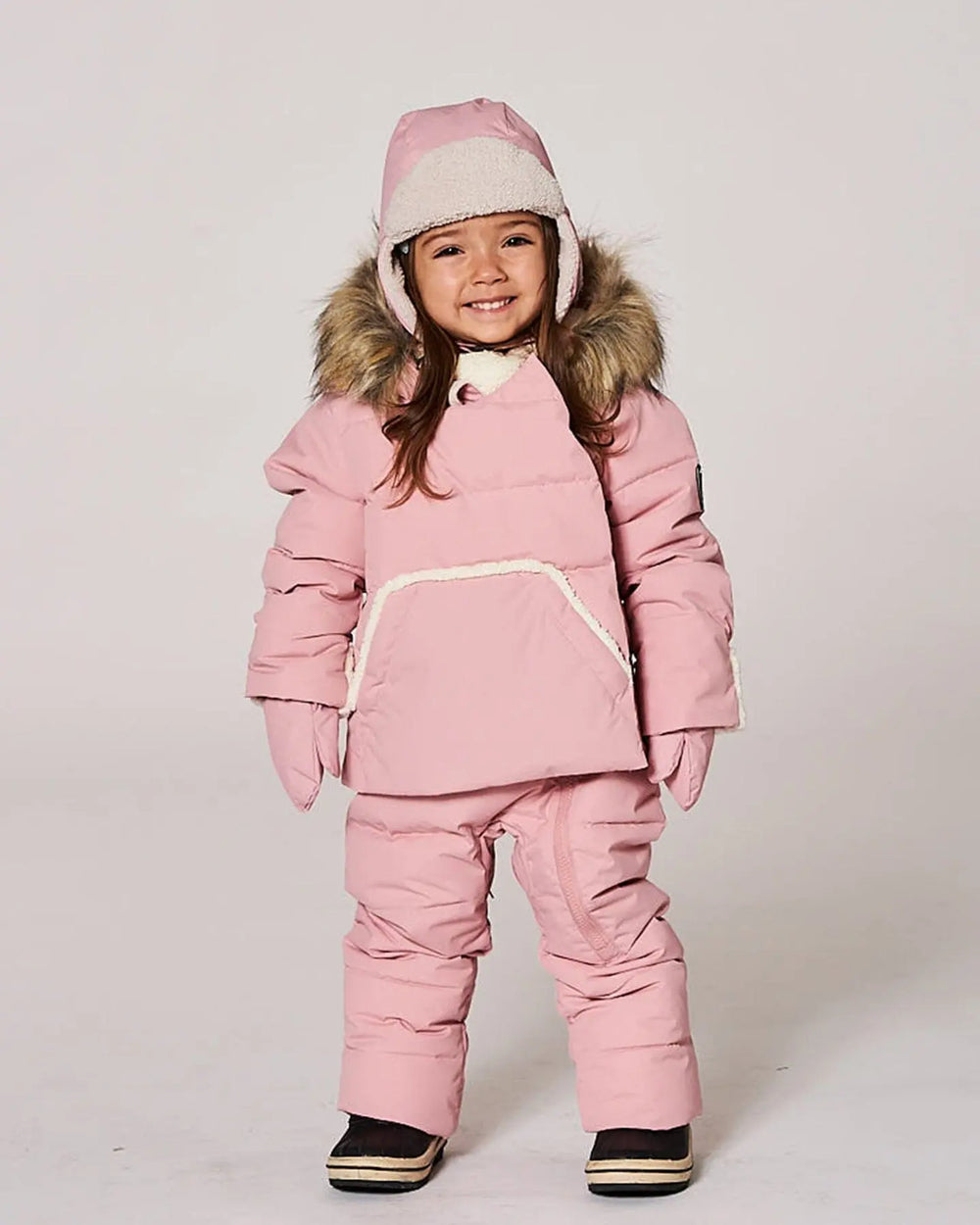 Toddler wearing pink one-piece pram suit, waterproof-coated, cozy hood.