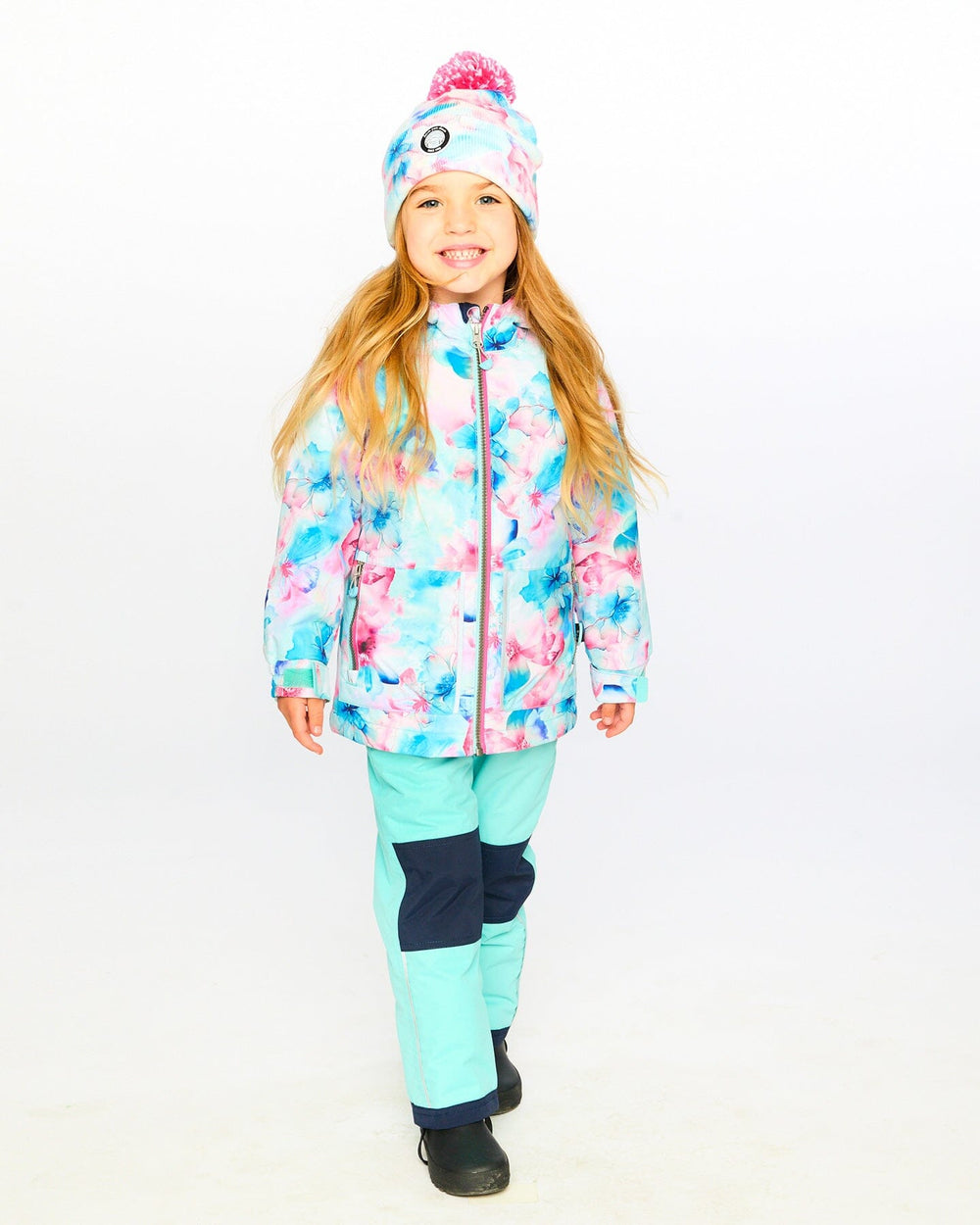 Ready for snow: child wearing Deux par Deux turquoise chill snowsuit outdoors