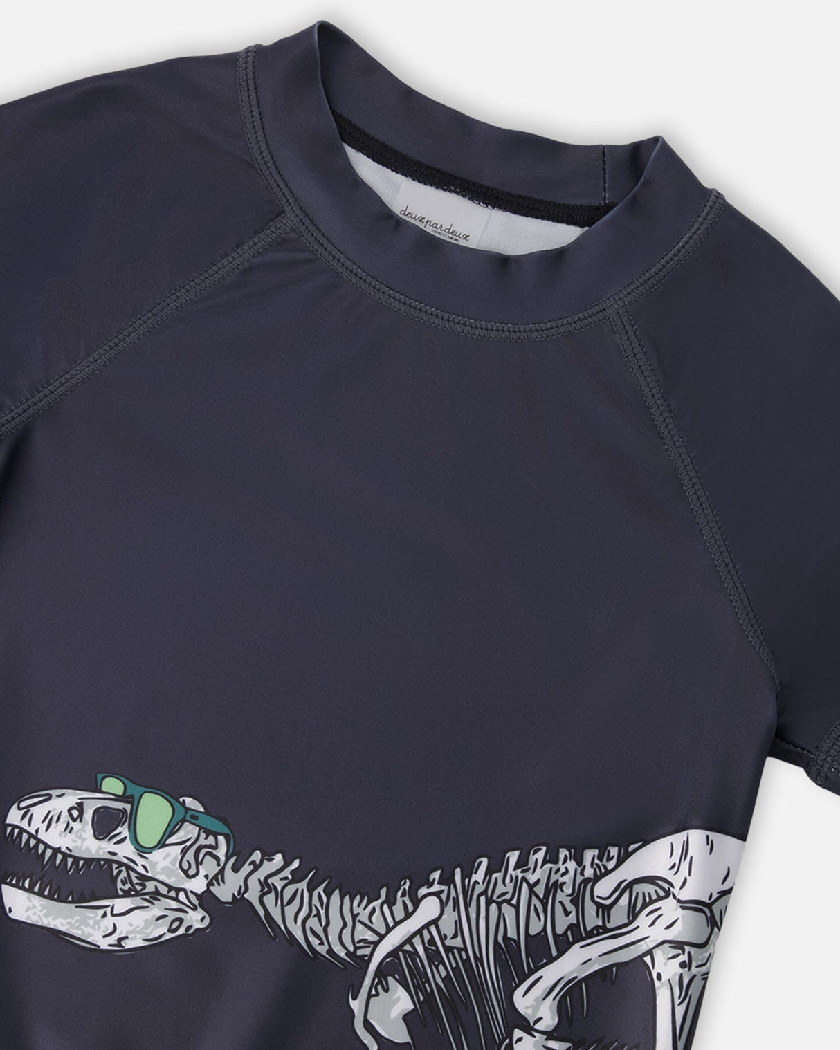 Close-up of neckline and dinosaur skeleton in sunglasses graphic on black rashguard top