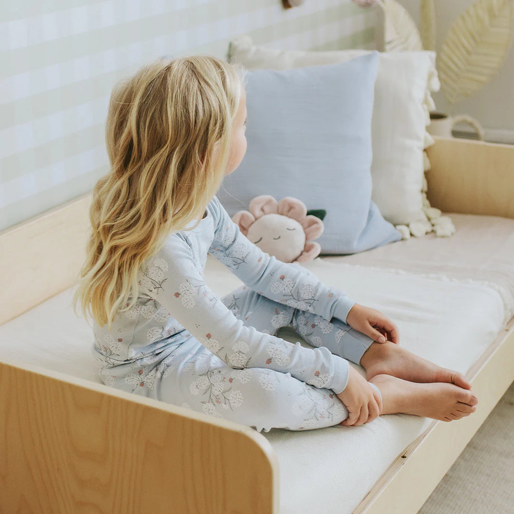 Toddler wearing sky blue hydrangea floral organic cotton pajama set by Petit Lem