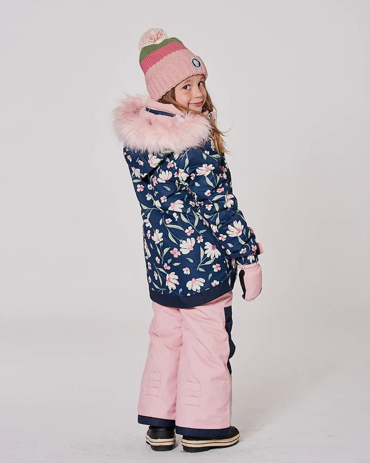 Child wearing Deux Par Deux flower print snowsuit side view