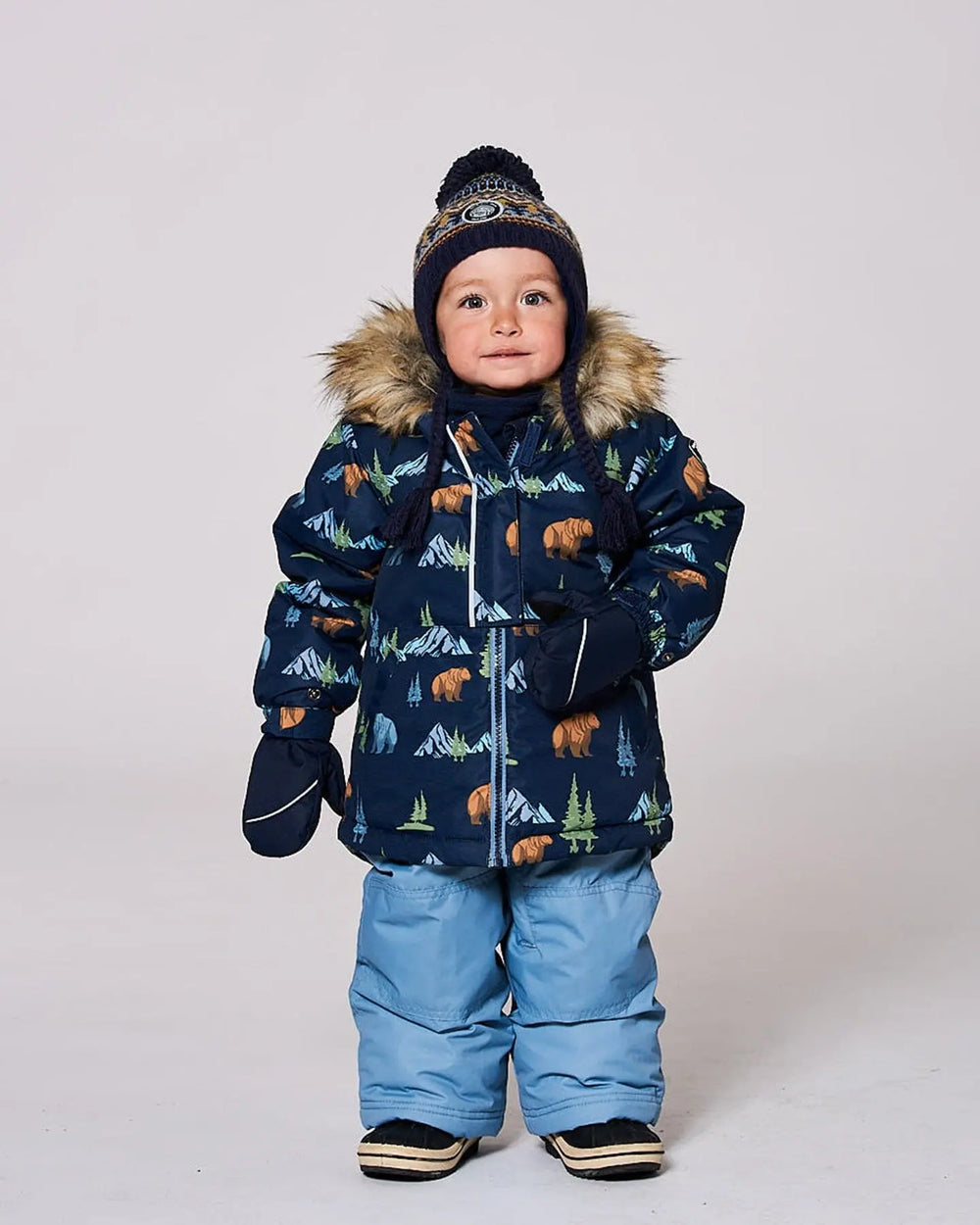 Toddler boy wearing blue/gray jacket and snow pants set with fleece-lined bib.