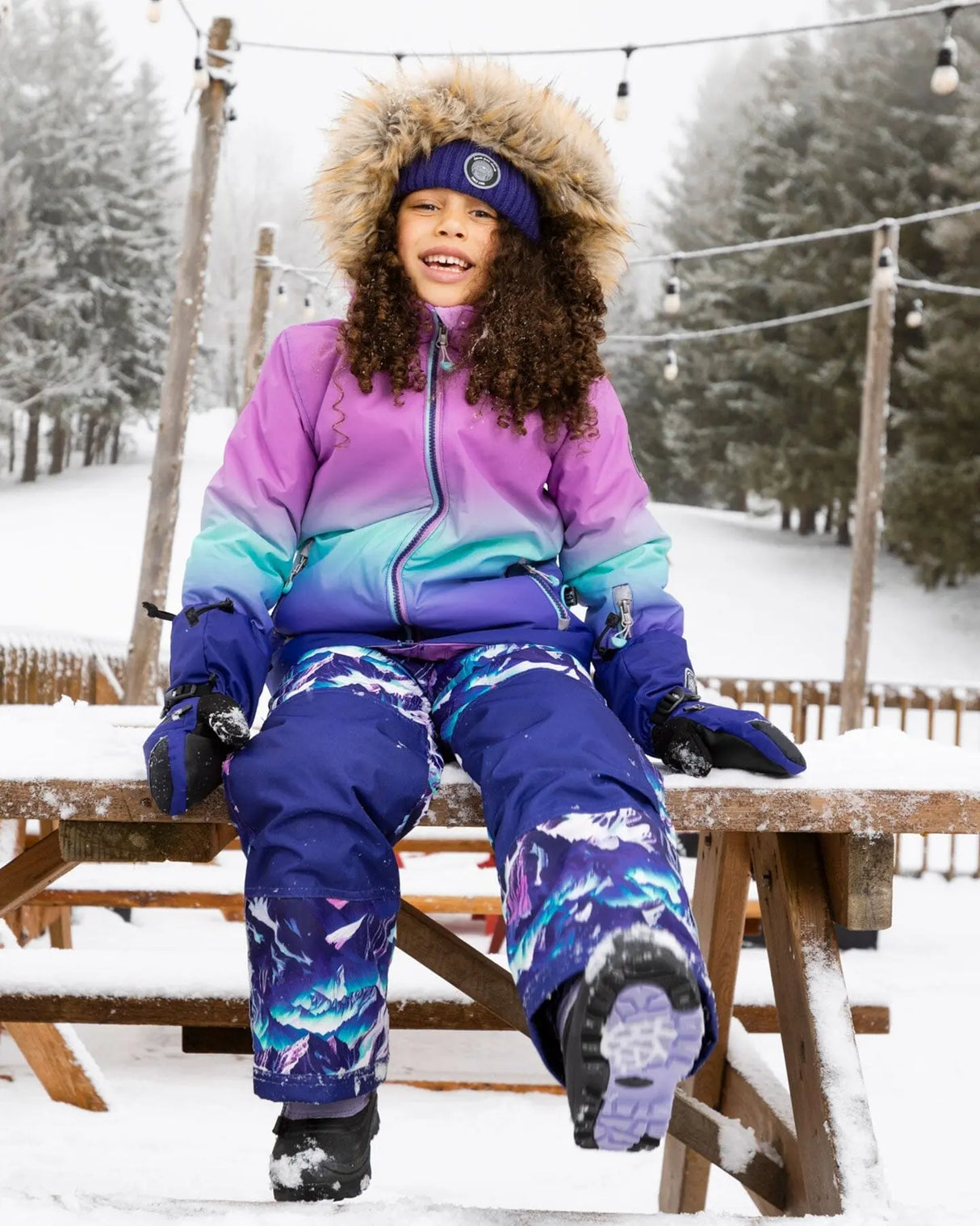 Action shot: purple Mountain jacket and snow pants, breathable and cozy on the hill.