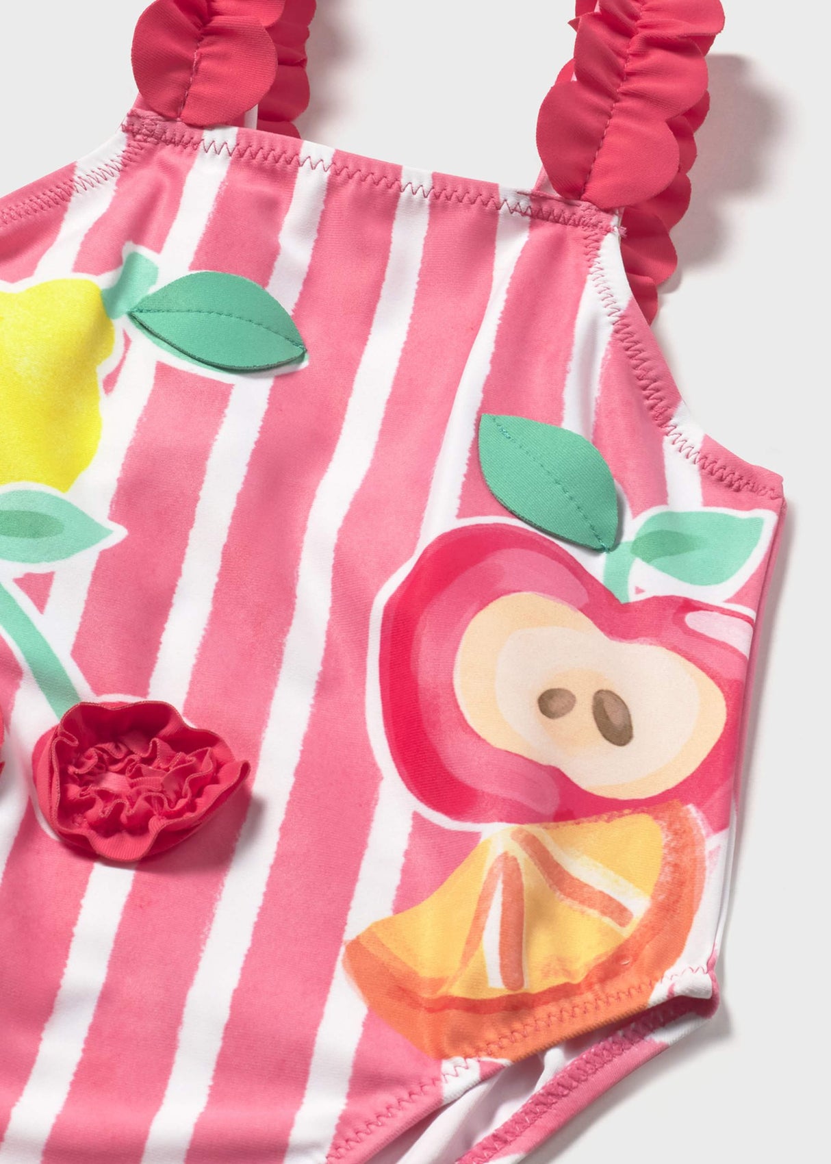 Closeup of Mayoral baby girl graphic swimsuit showing Pink stripes, ruffled strap, and colorful print.