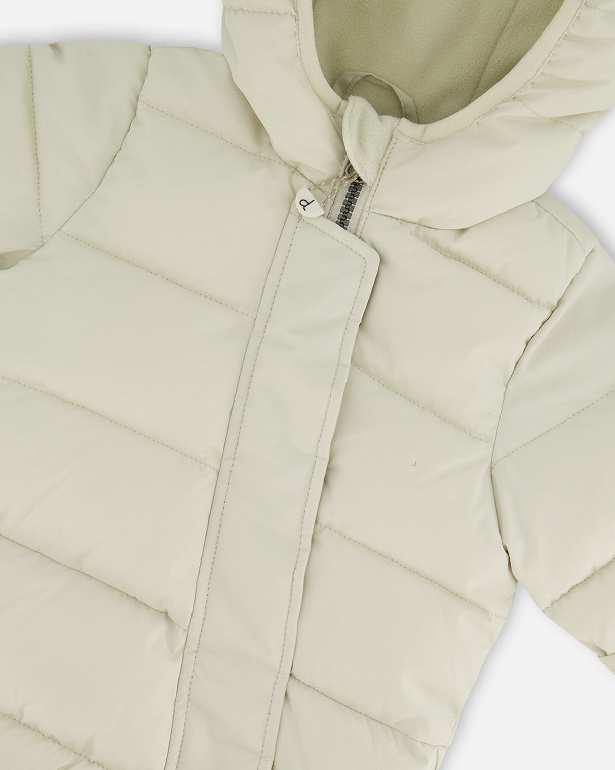 Close-up PrimaLoft quilting of off-white baby snowsuit