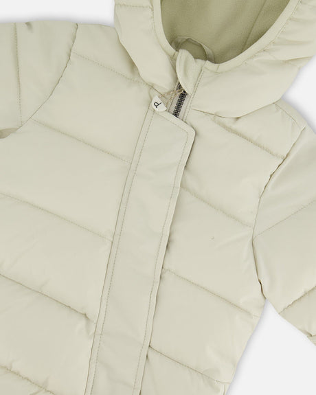 Close-up PrimaLoft quilting of off-white baby snowsuit