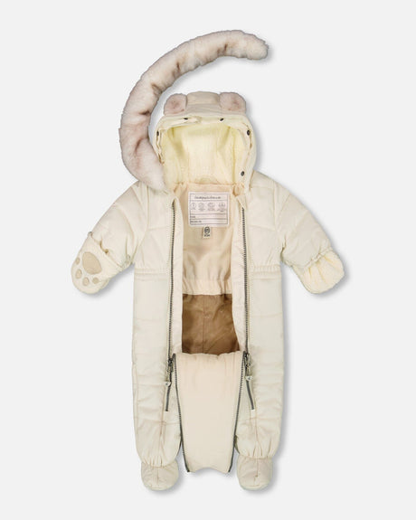 Lifestyle photo of a baby wearing the White Asparagus Layette snowsuit outdoors