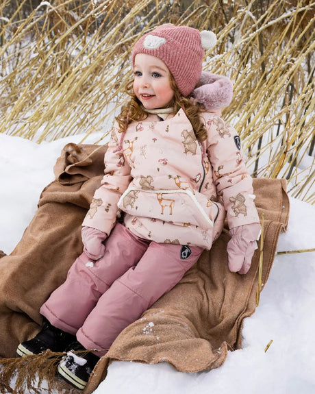 Toddler wearing Deux par Deux Baby Snug snowsuit in dusty pink
