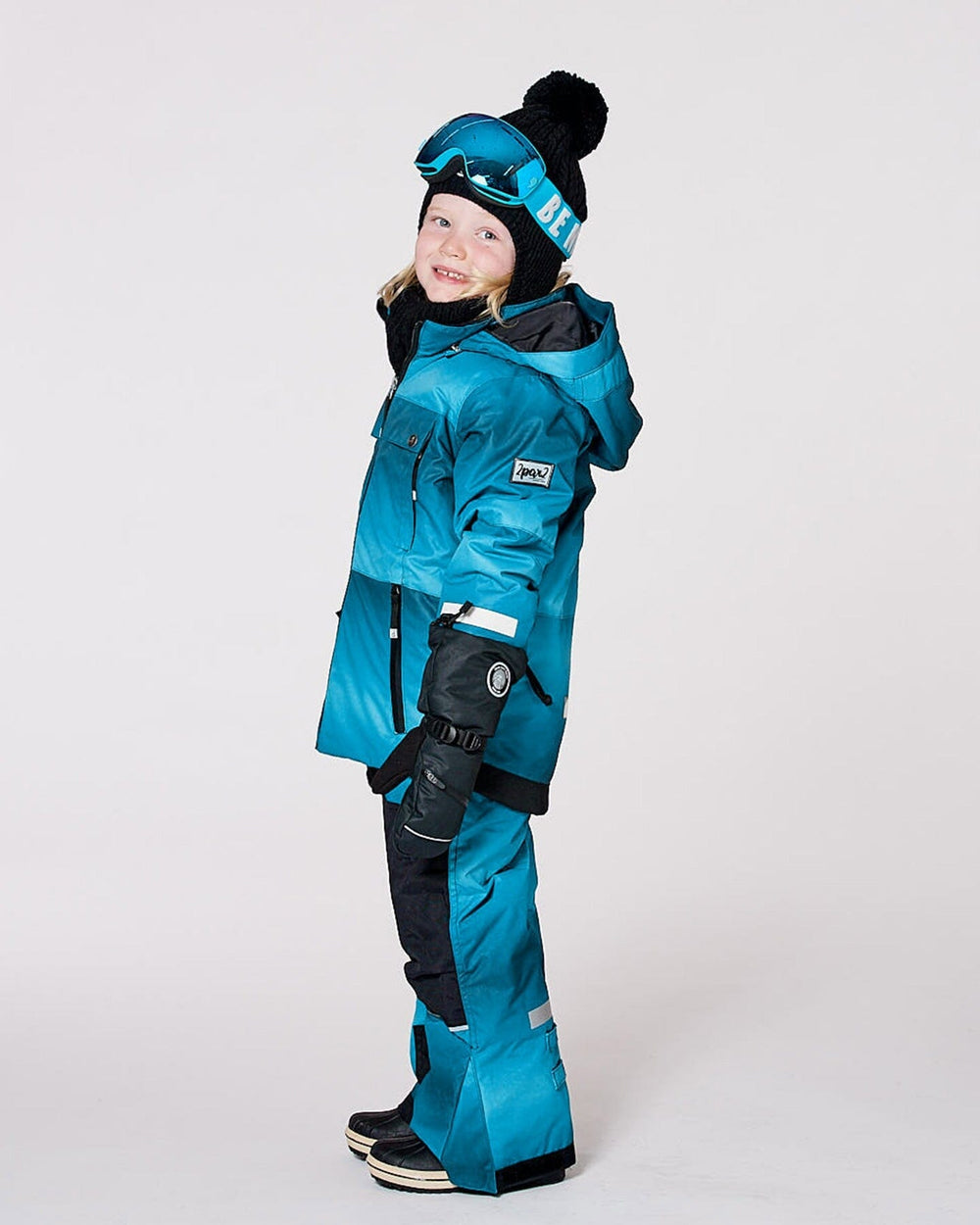 Child wearing Deux par Deux teal gradient insulated snowsuit outdoors