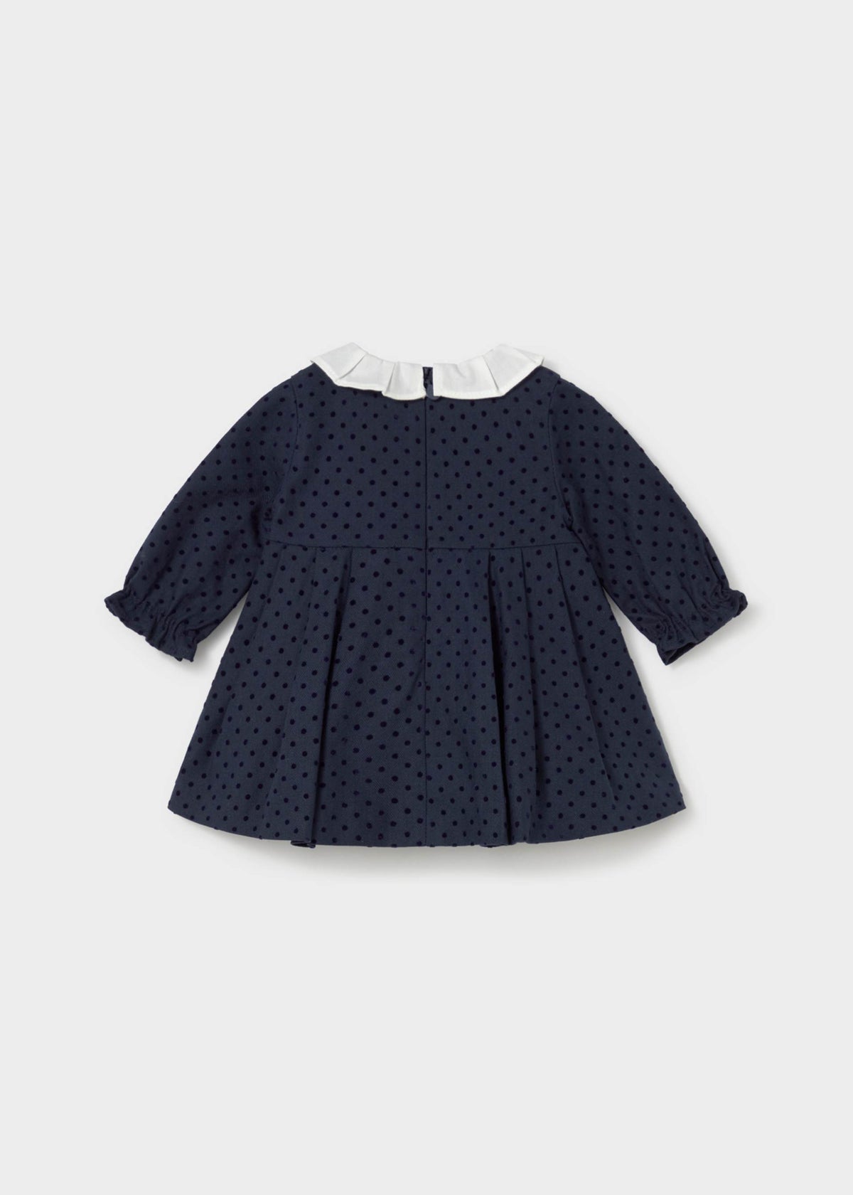 Back view of the navy polka dot dress with back zipper and pleated skirt