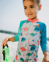 Baby boy wearing grey dinosaur one-piece swimsuit front view with long sleeves