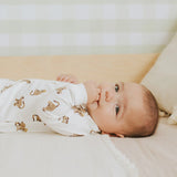 Baby in organic cotton monkey print sleeper with ribbed cuffs