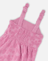 Close-up of straps and flower motif on pink beach cover-up dress for girls