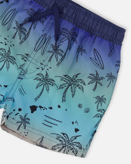 Close-up of waistband, drawstring, and palm-tree beach print on blue swim shorts