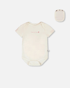 Deux par Deux white organic cotton bodysuit with chest message for baby girls, front view