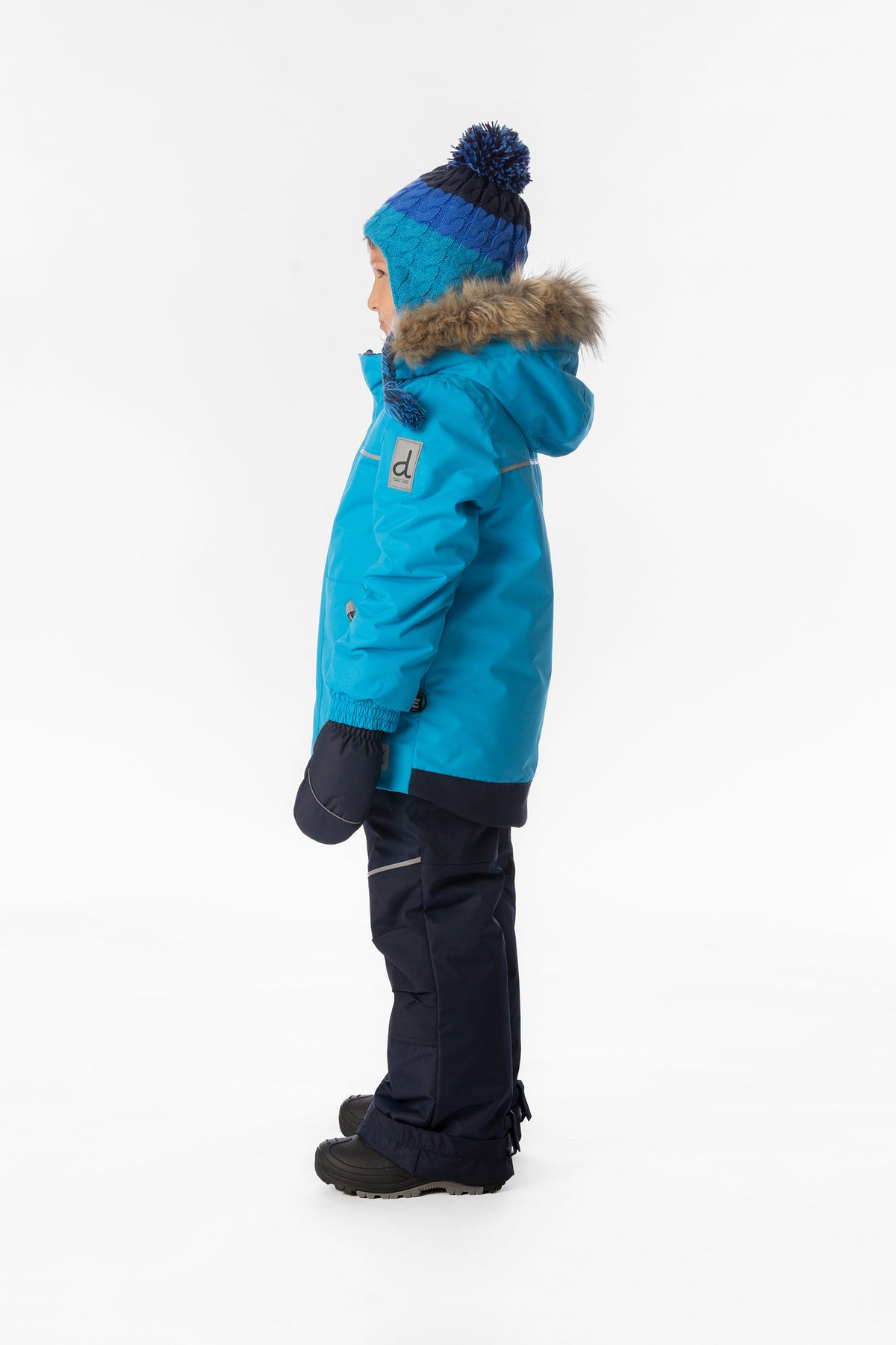 Child wearing the blue Deux par Deux DISCOVER snowsuit, lookbook view 2