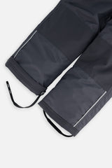 Close-up of the charcoal CHILL snow pant leg with adjustable foot strap and reflective trim