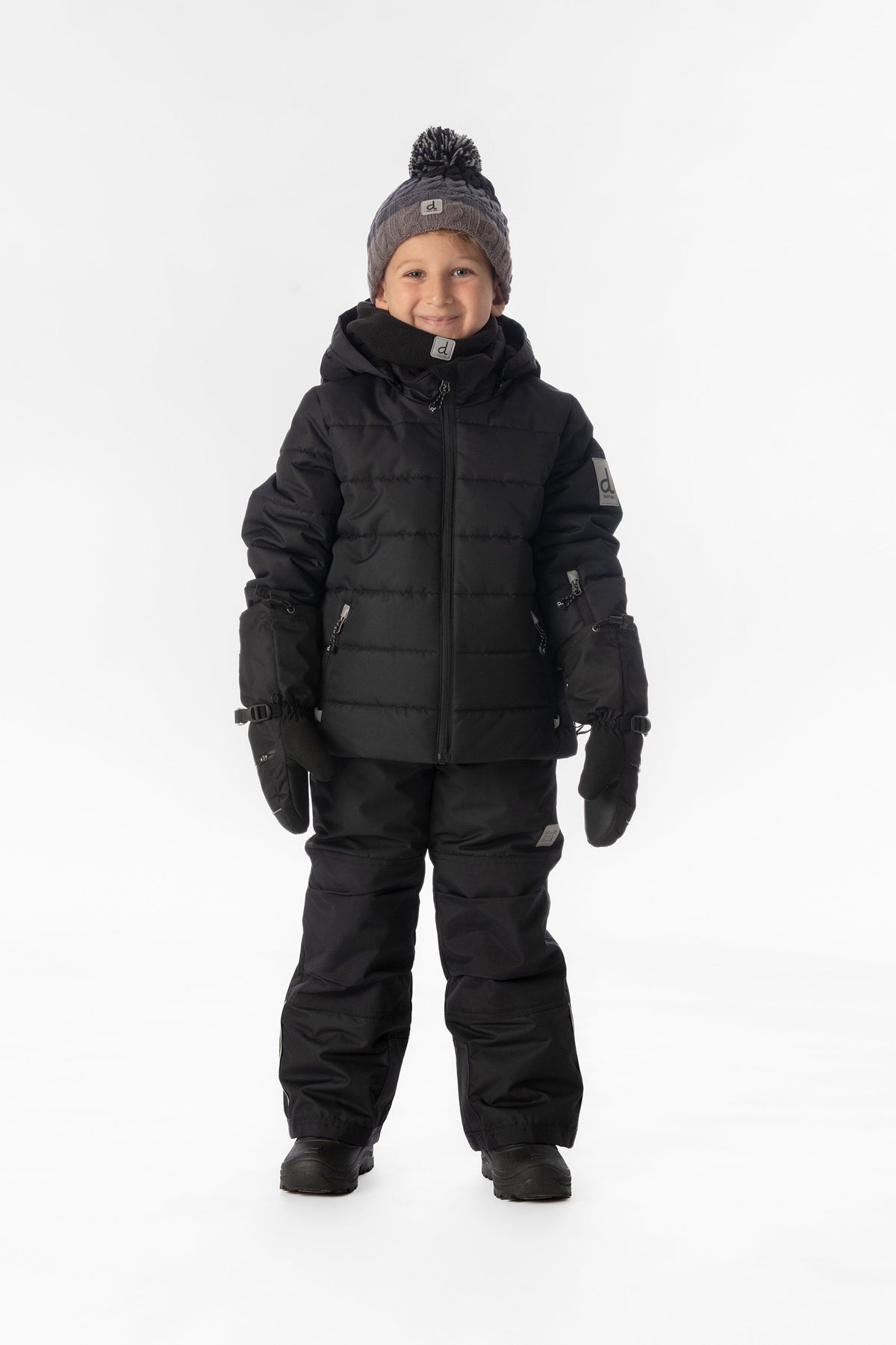 Child wearing the black Deux par Deux PLAY snowsuit, lookbook view 1