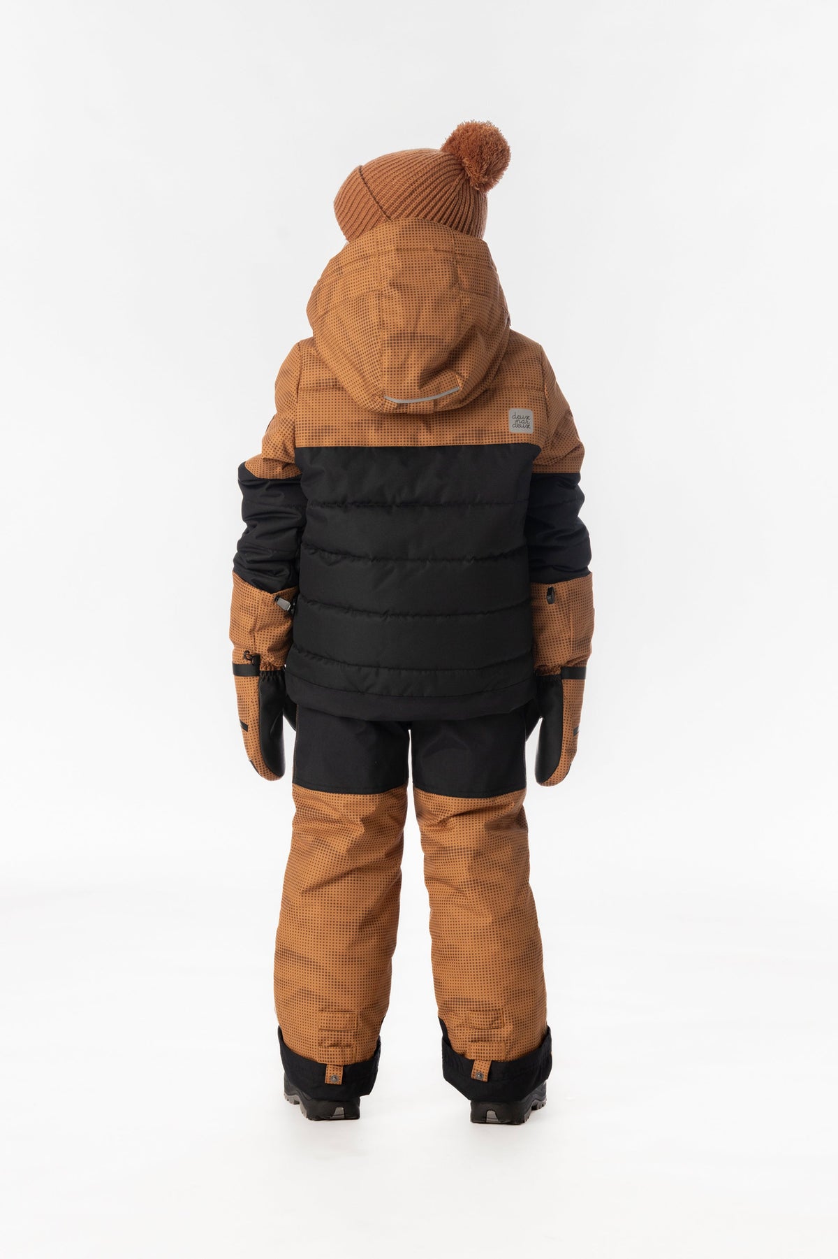 Child wearing the Deux par Deux PLAY snowsuit in brown and black, lookbook view 3