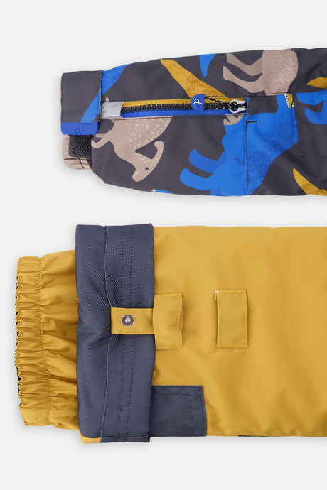 Close-up of the dinosaur PLAY jacket sleeve ski-pass pocket and the adjustable yellow pant hem