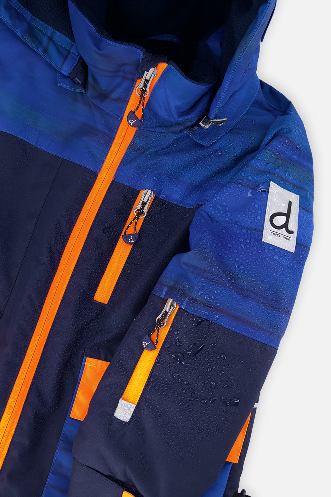 Close-up of the navy jacket orange zipper, pockets and logo patch