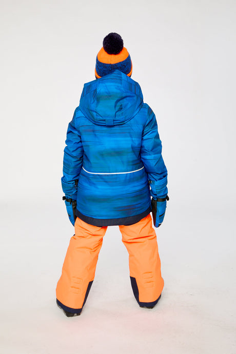 Back view of a boy wearing the blue jacket and orange snow pants